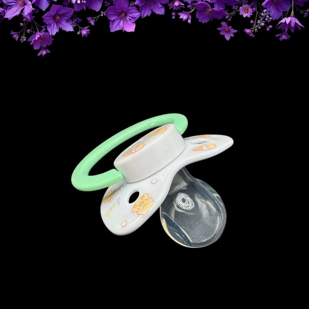 ABDL pacifier featuring a cute yellow duck design on the shield and button, adding a playful and adorable touch.