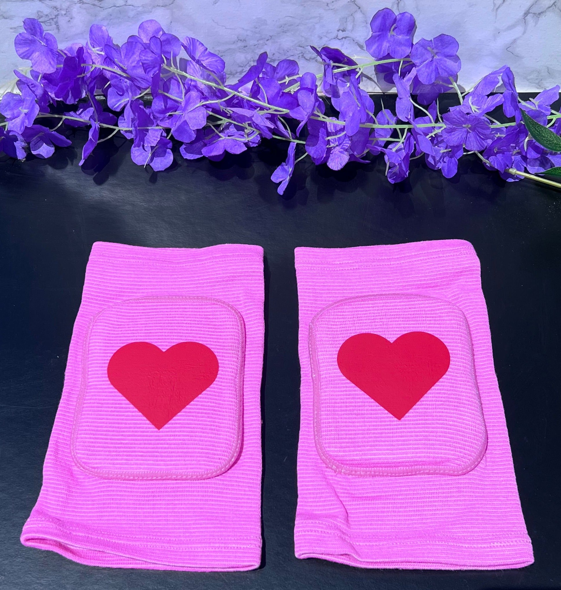 Adult knee pads featuring a soft, comfortable design with a heart symbol in the center, adding a sweet and playful touch.