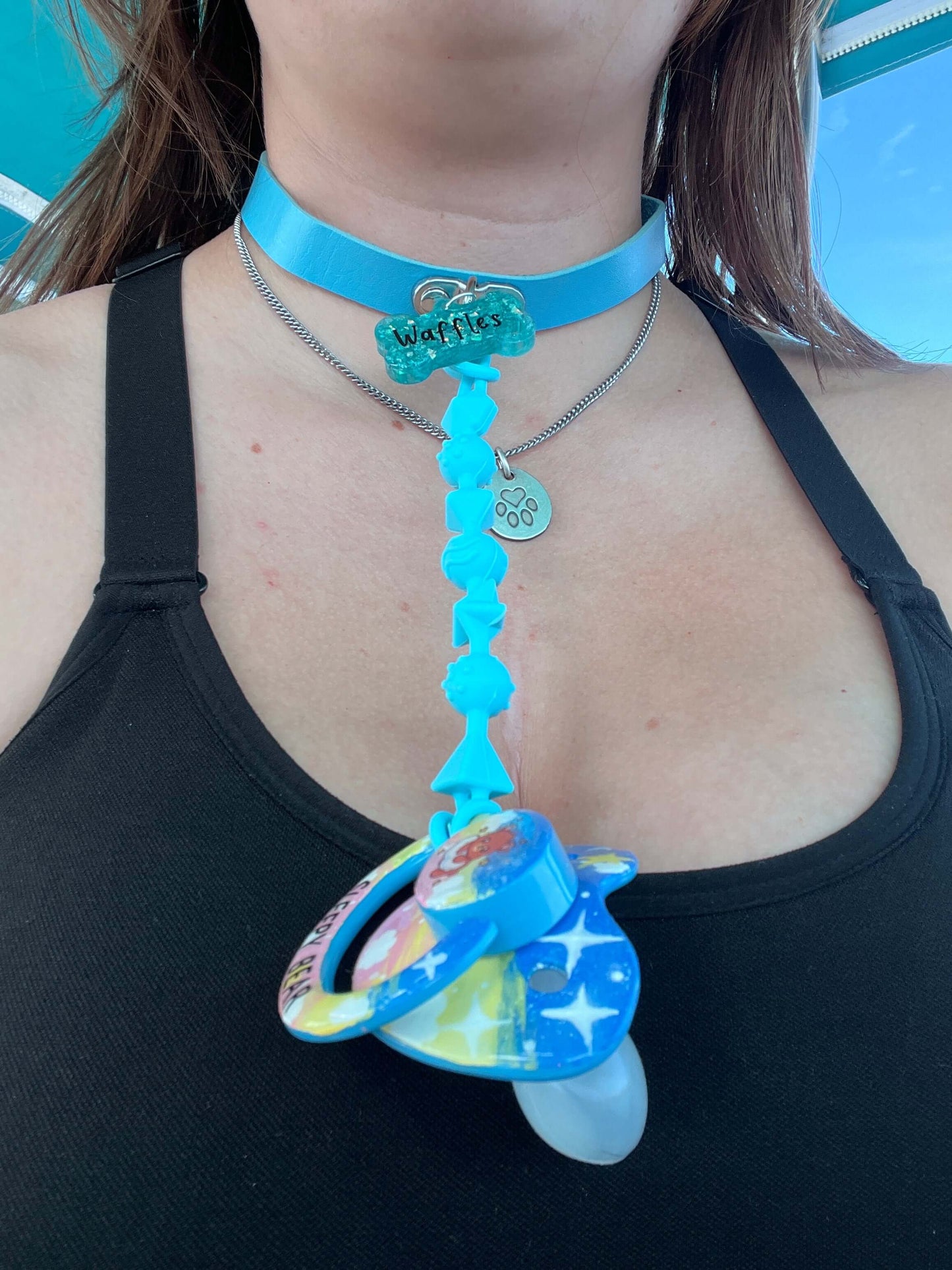 Custom adult pacifier choker featuring a leather choker, an attached adult pacifier, and a customizable resin dog tag for a personalized touch.