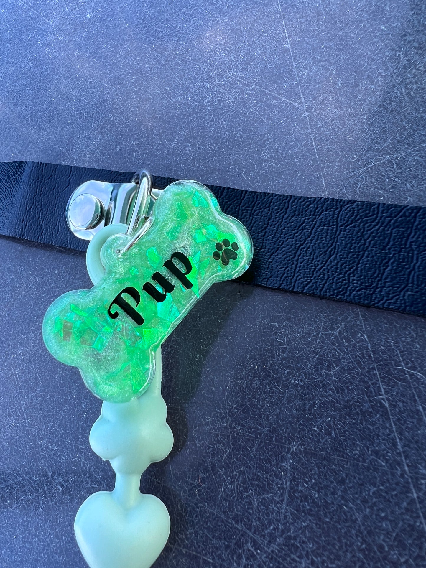 Adult pacifier choker featuring a comfortable choker with an attached adult pacifier, connected by a chewable silicone string. A customizable resin name tag is displayed at the center for personalization.