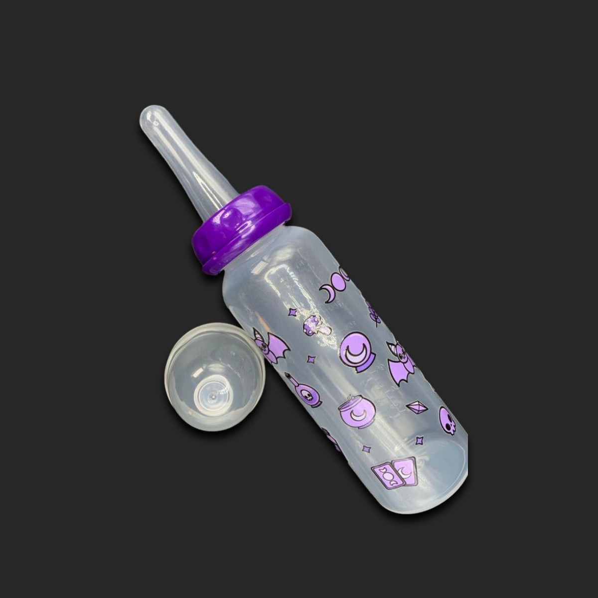 An 8oz adult baby bottle with a purple witch theme, featuring magical designs like bats, tarot cards, potions, stars, and moons wrapping around the bottle for a whimsical and enchanting look.