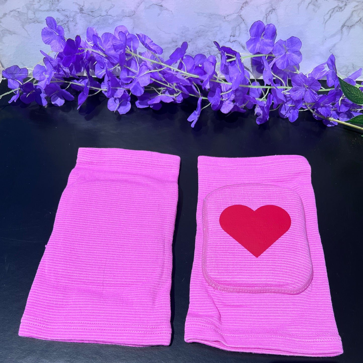 Adult knee pads featuring a soft, comfortable design with a heart symbol in the center, adding a sweet and playful touch.