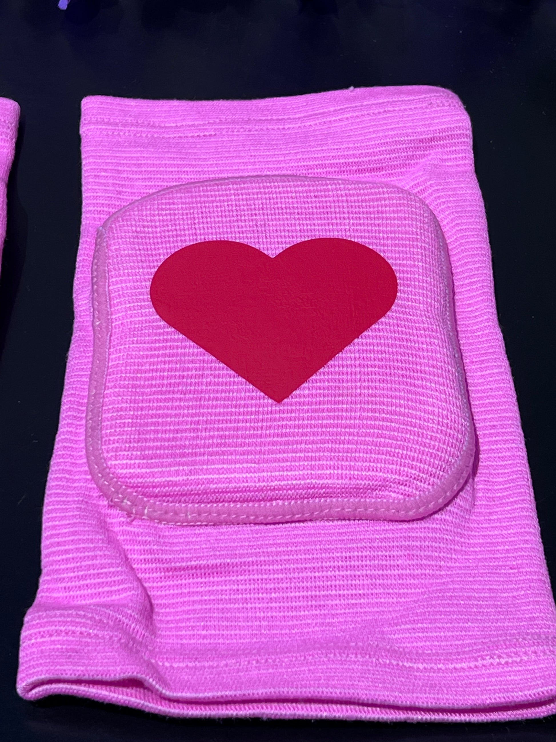 Adult knee pads featuring a soft, comfortable design with a heart symbol in the center, adding a sweet and playful touch.