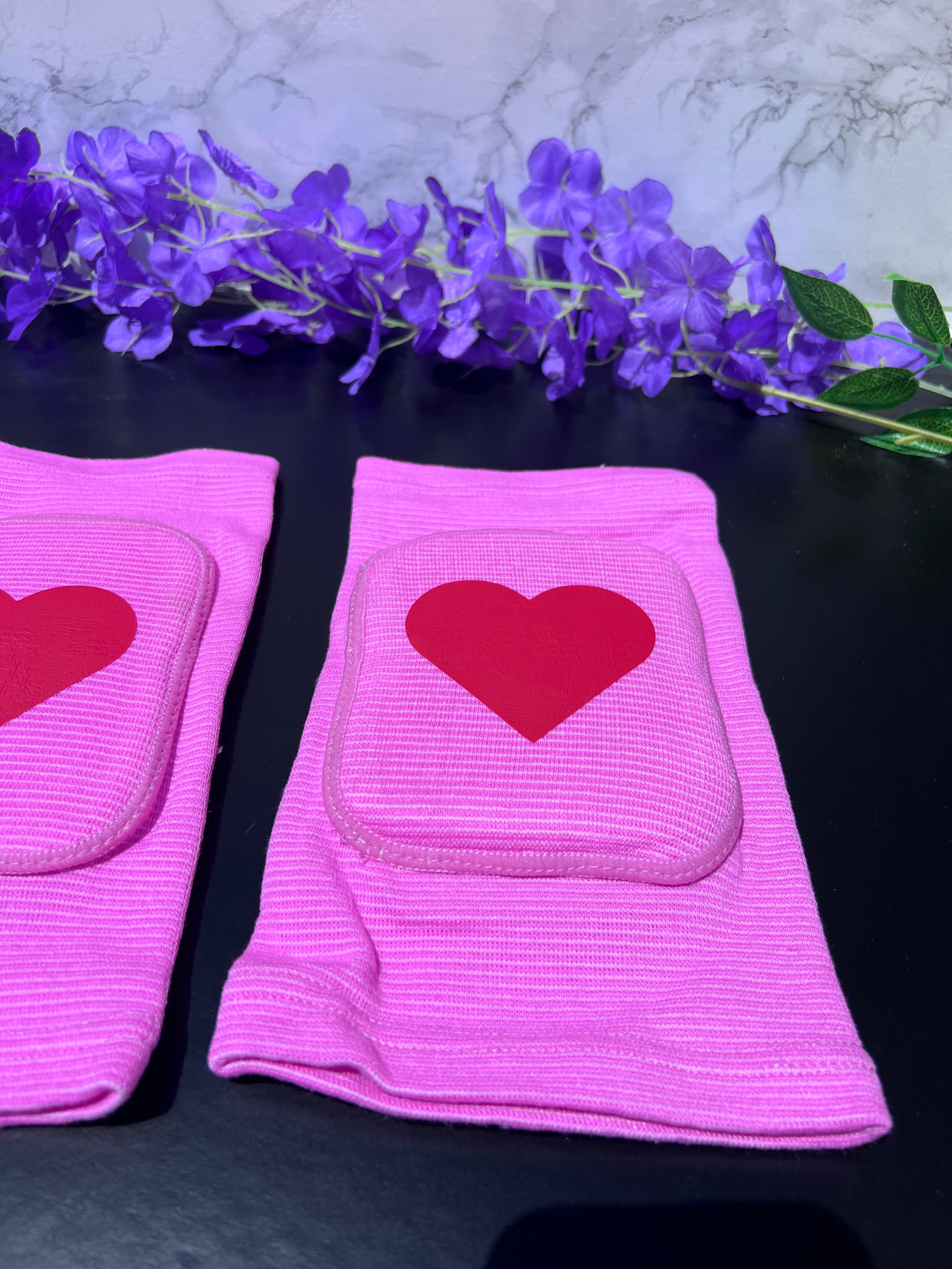 Adult knee pads featuring a soft, comfortable design with a heart symbol in the center, adding a sweet and playful touch.