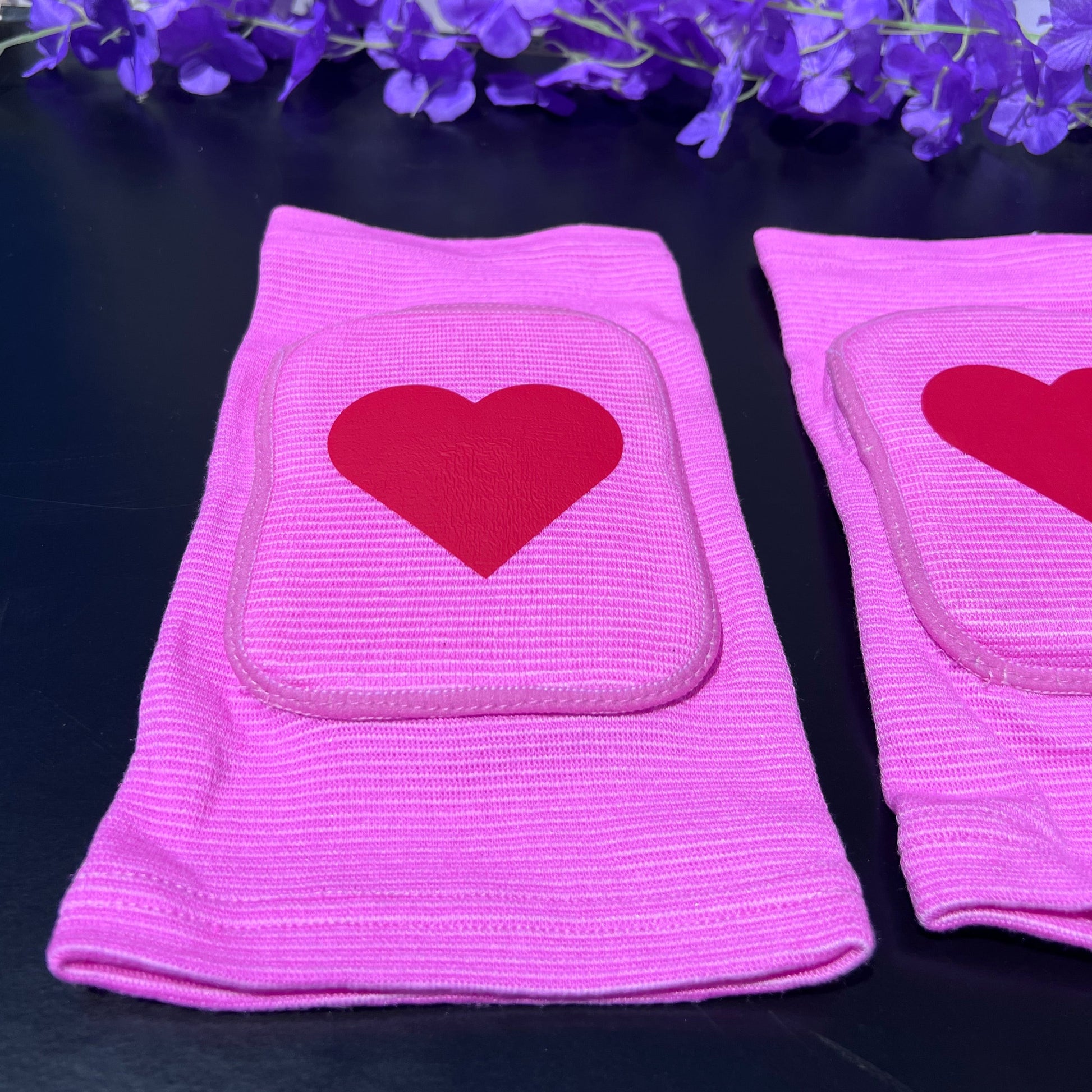 Adult knee pads featuring a soft, comfortable design with a heart symbol in the center, adding a sweet and playful touch.
