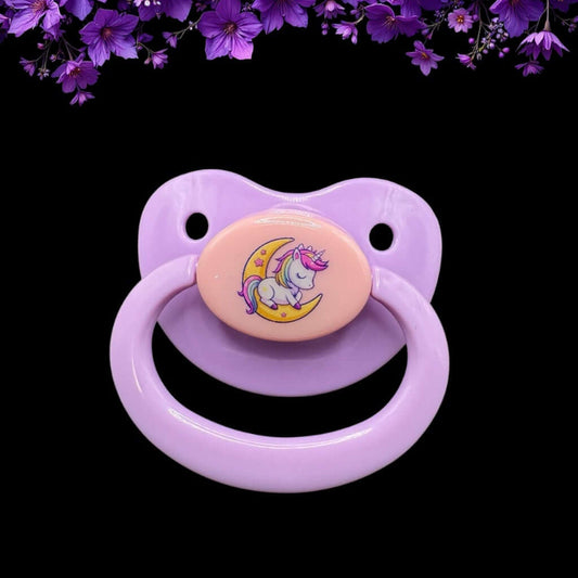 Enjoy our adorable adult pacifier featuring a Kawaii unicorn sitting on the moon in the center with the option to add your own custom text to the handle.