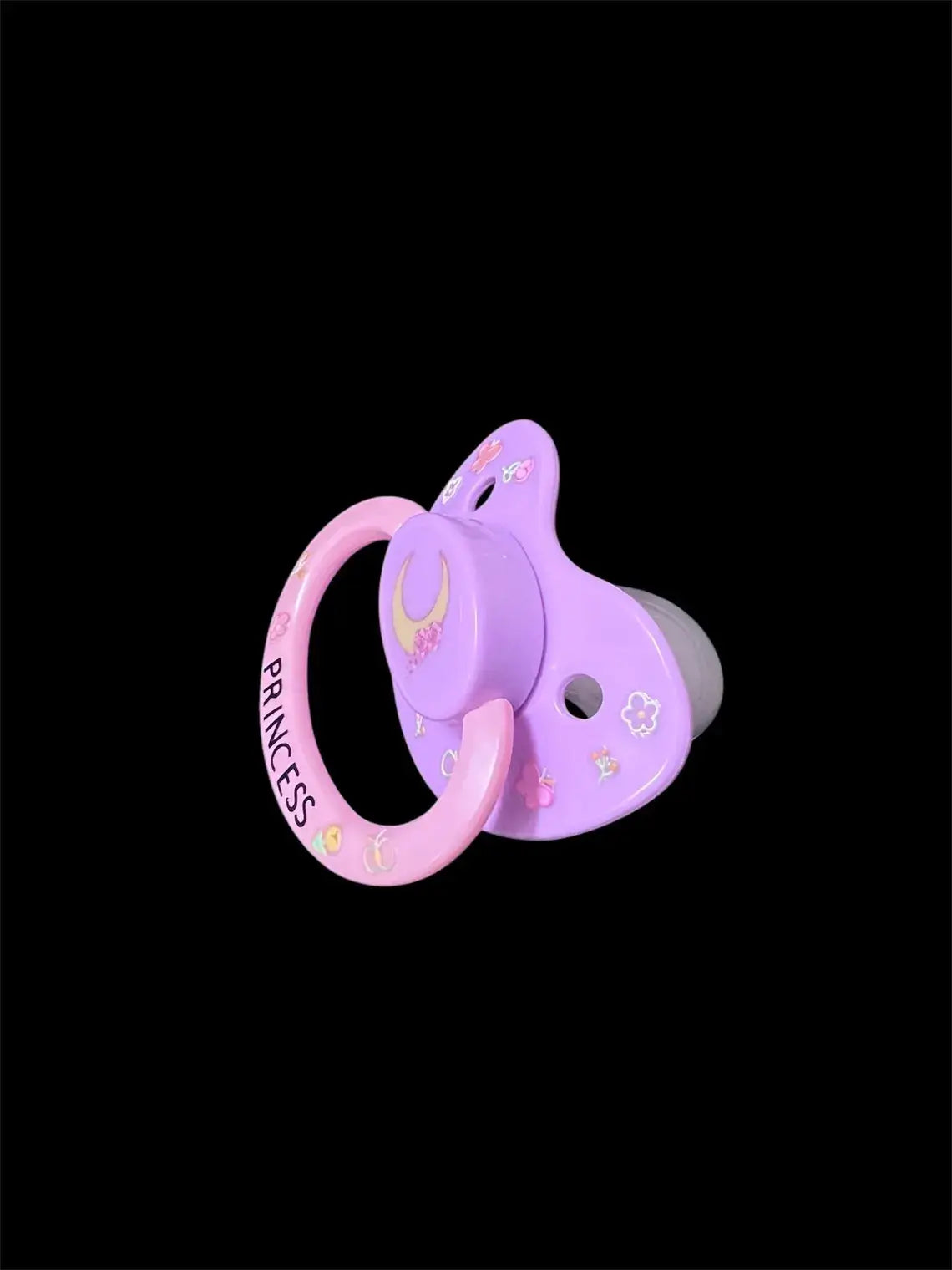 Adult deco pacifier featuring glow-in-the-dark flowers on the shield, a moon centerpiece, and the word 'Princess' on the handle for a magical and elegant design.