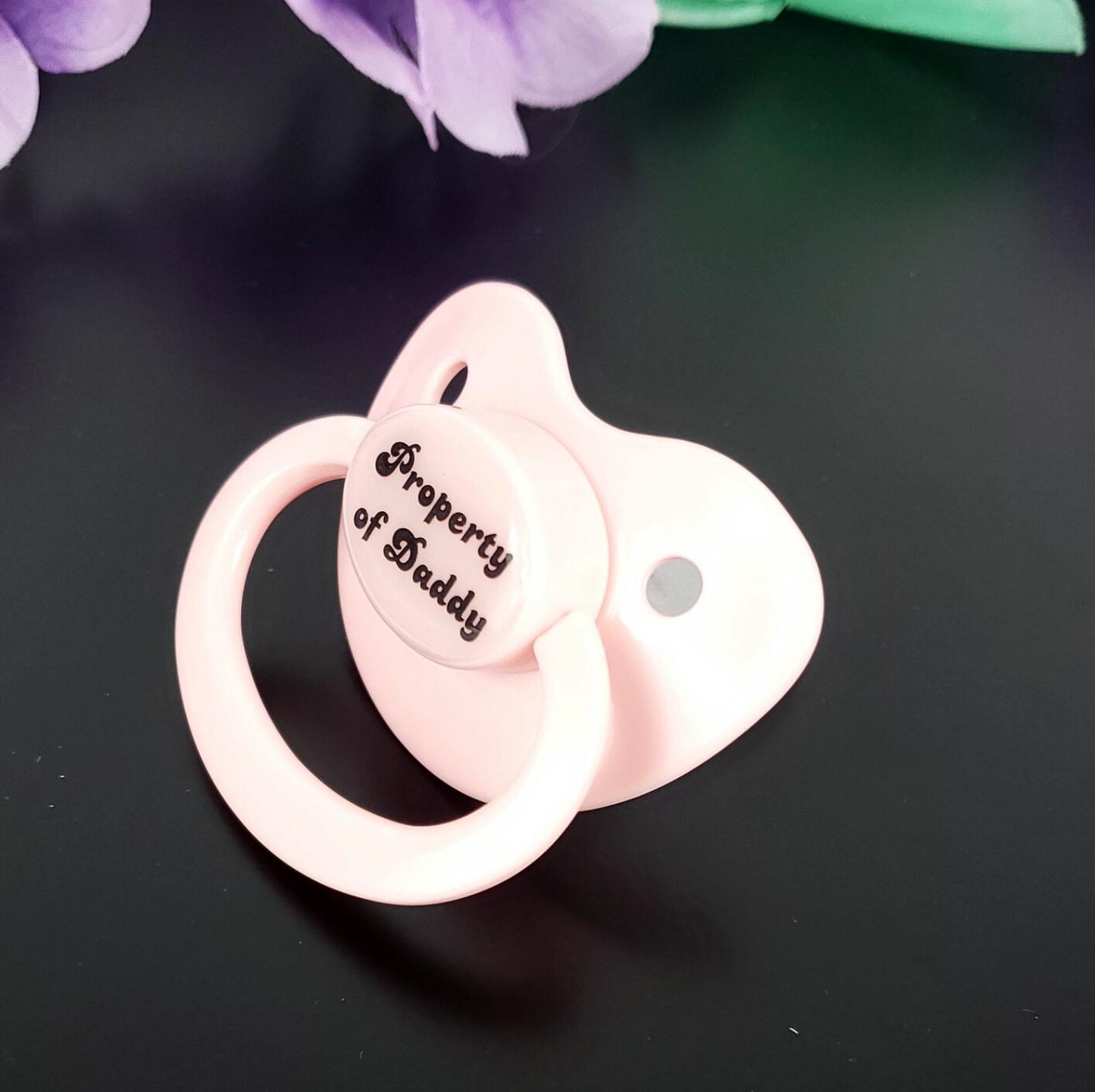 Baby Pink adult pacifier with bold text saying "Property of Daddy" in the center, adding a playful and loving sentiment.