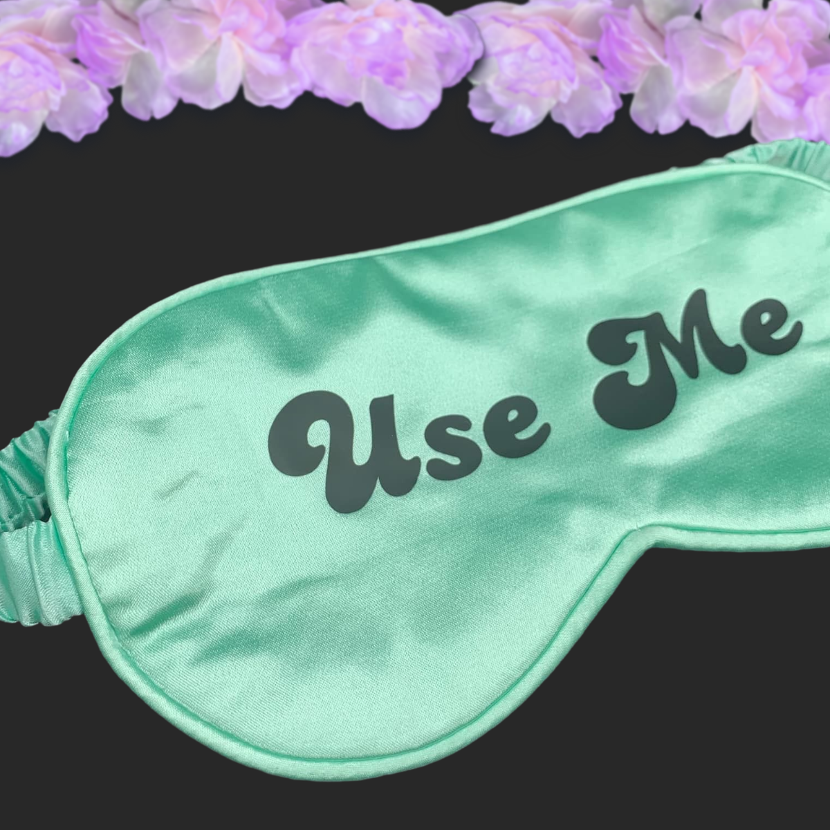 Mint satin eye mask with the text "Use Me" in black lettering