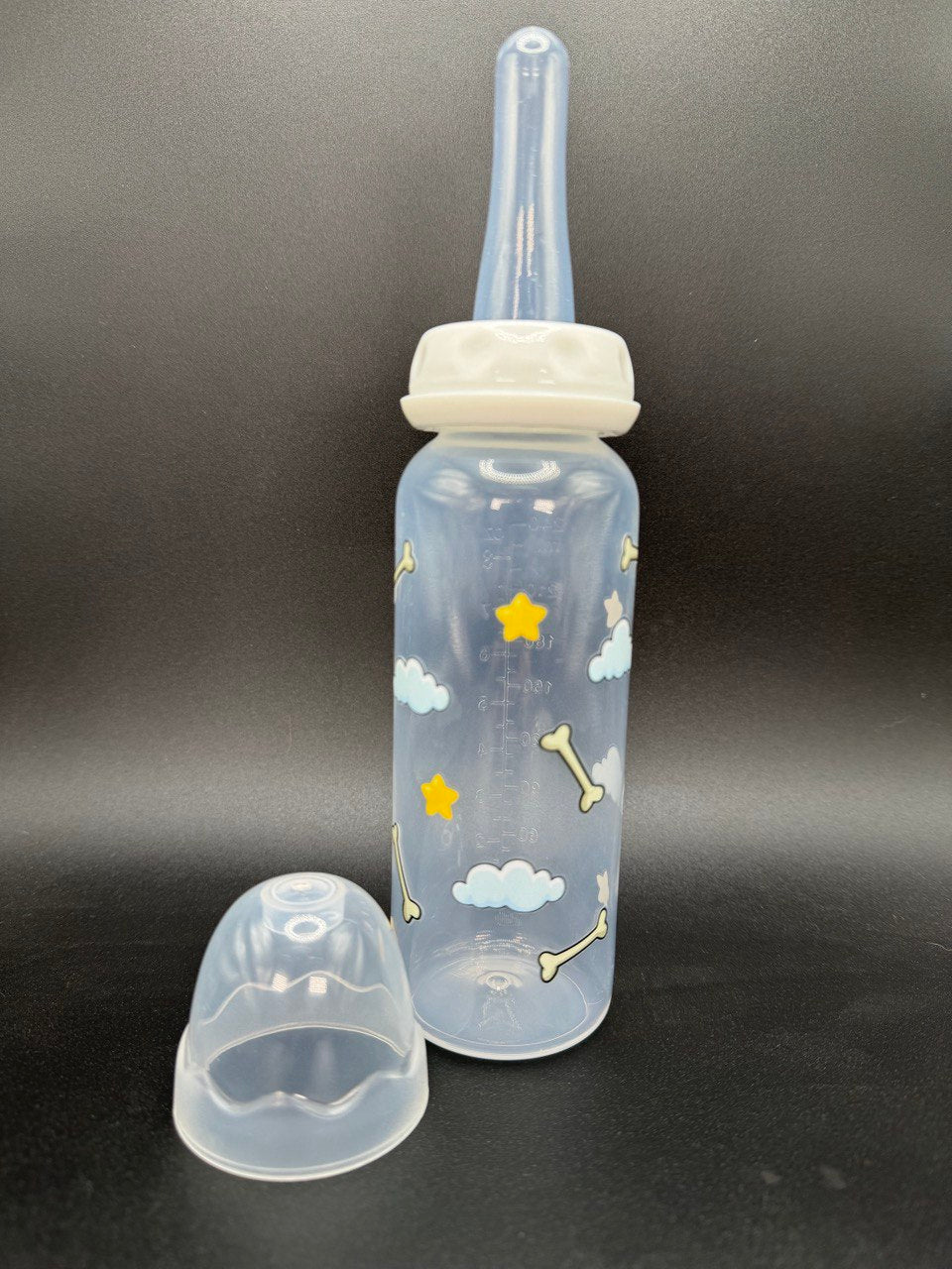 Nighttime dog-themed adult baby bottle featuring a wrap-around design of dog bones, fluffy clouds, and twinkling stars, creating a cozy and comforting aesthetic.