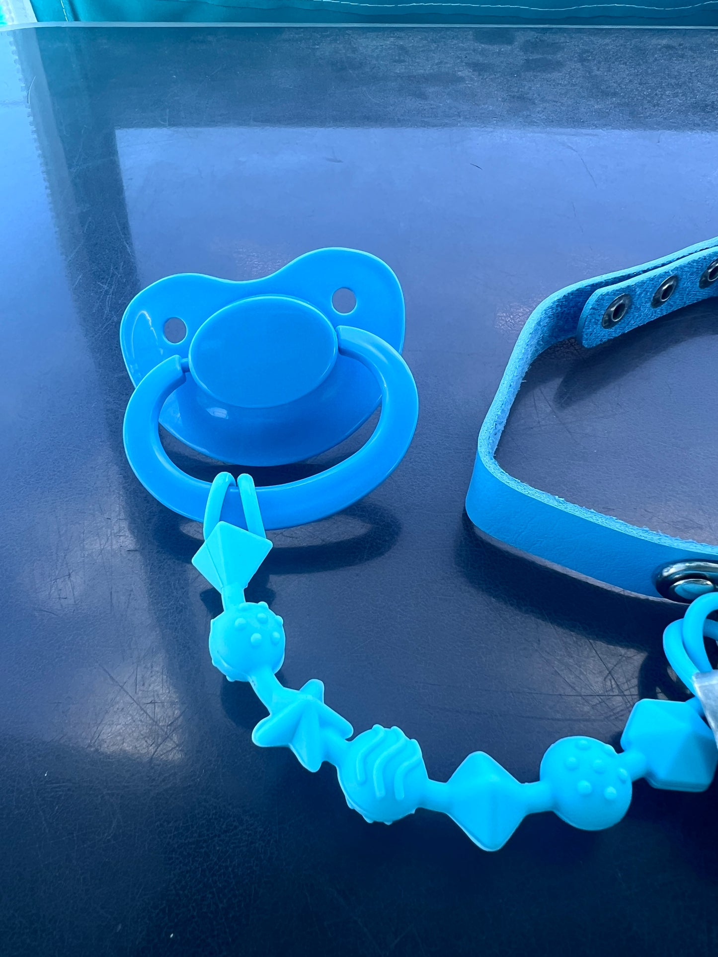 Close up of chewable silicone strand pacifier clip attached to adult pacifier