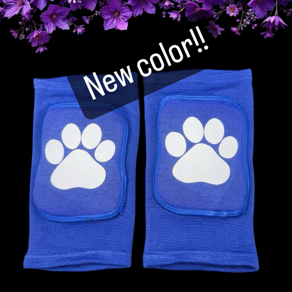 Blue knee pads with white paw prints on a black background with purple flowers at the top.