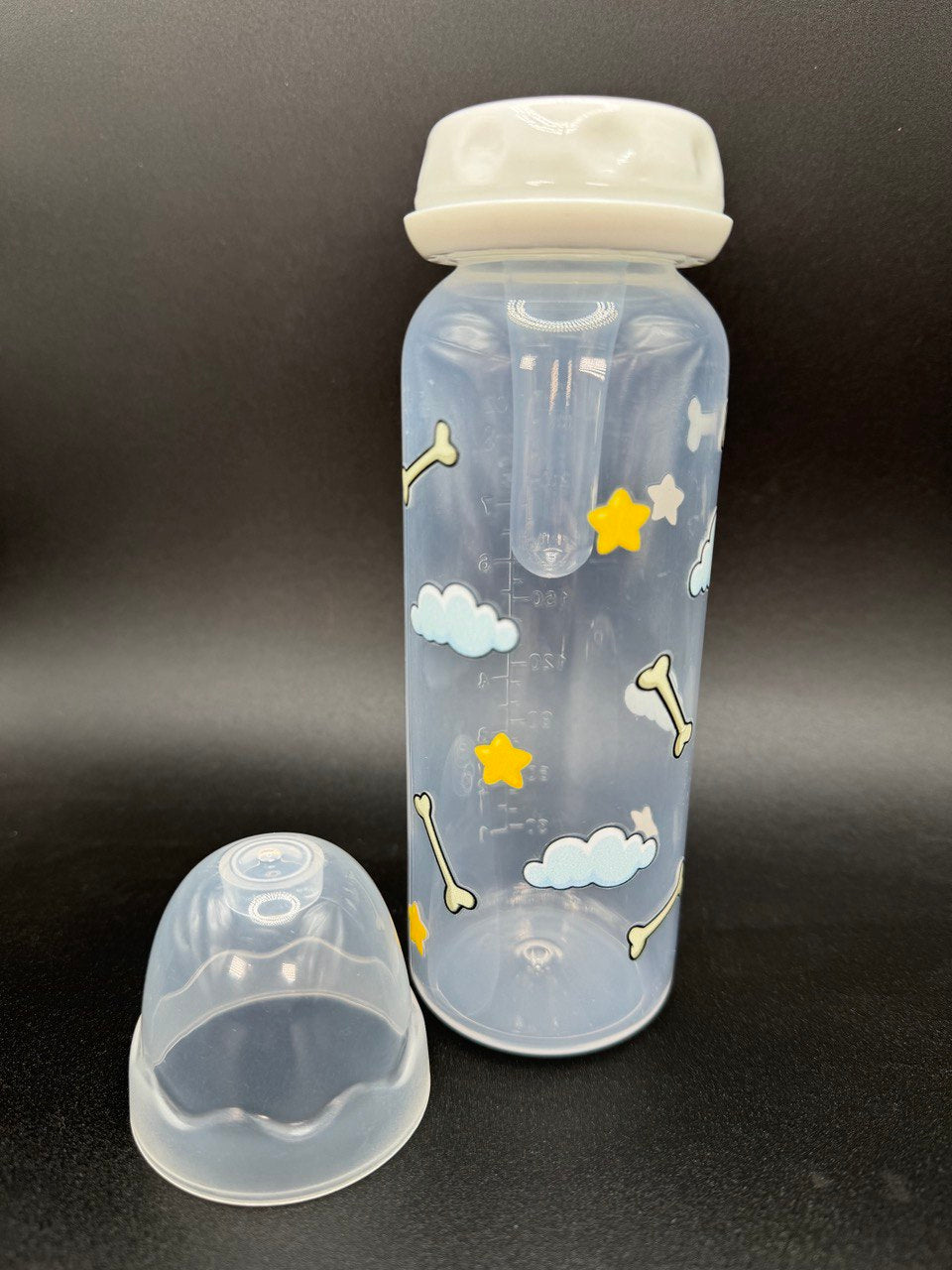Nighttime dog-themed adult baby bottle featuring a wrap-around design of dog bones, fluffy clouds, and twinkling stars, creating a cozy and comforting aesthetic.