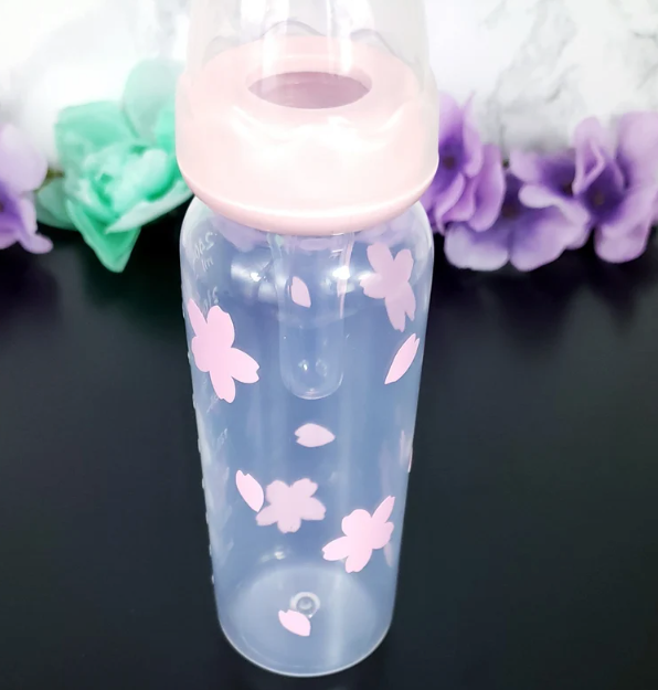 An 8oz adult baby bottle featuring a delicate sakura cherry blossom theme, with soft pink flowers and petals elegantly wrapping around the bottle for a serene and charming design.