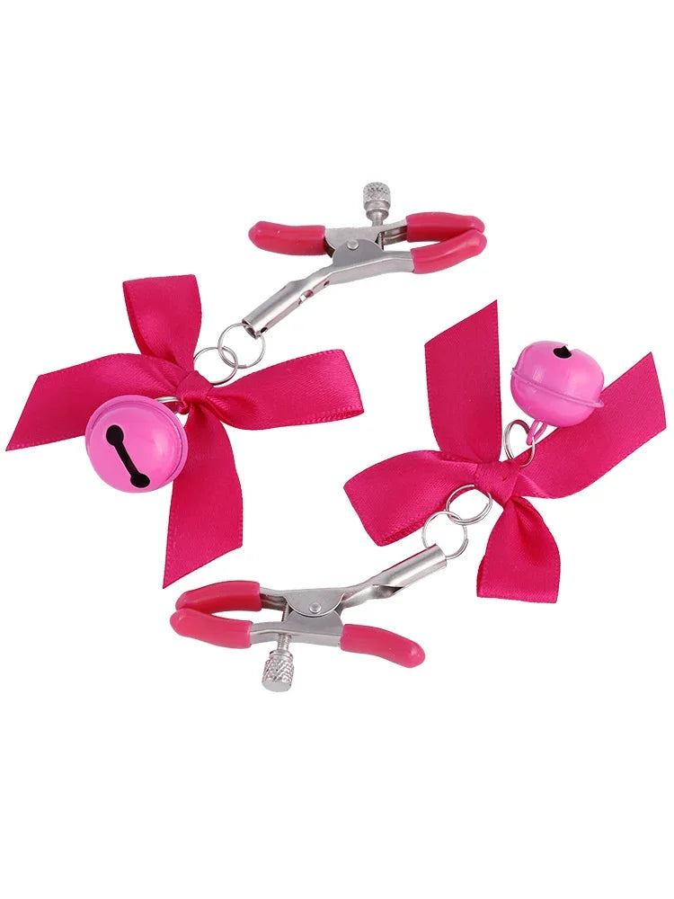 Stainless steel nipple clamps with pink attached bows and bells at the ends, featuring a silicone cover for added comfort and a stylish, playful touch.