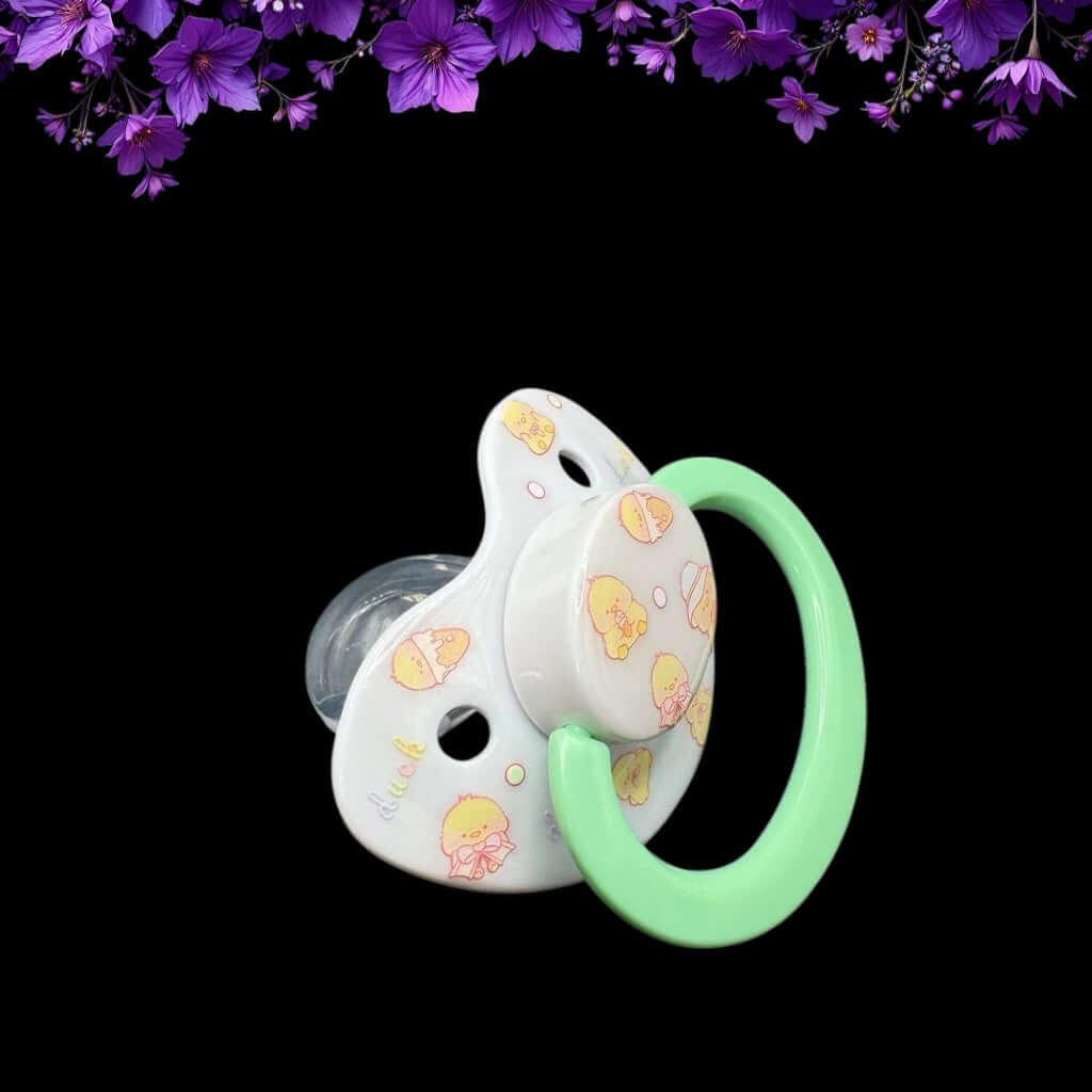 Adult baby pacifier featuring a cute yellow duck design on the shield and button, adding a playful and adorable touch.
