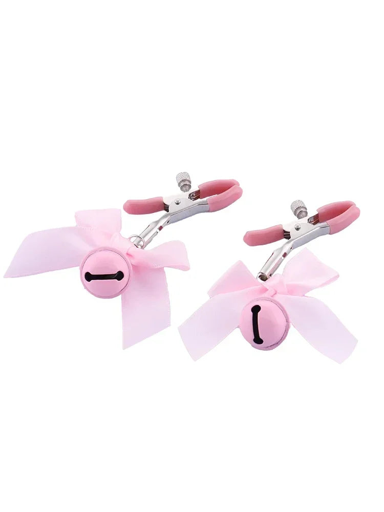 Stainless steel nipple clamps with attached bows and bells at the ends, featuring a silicone cover for added comfort and a stylish, playful touch.