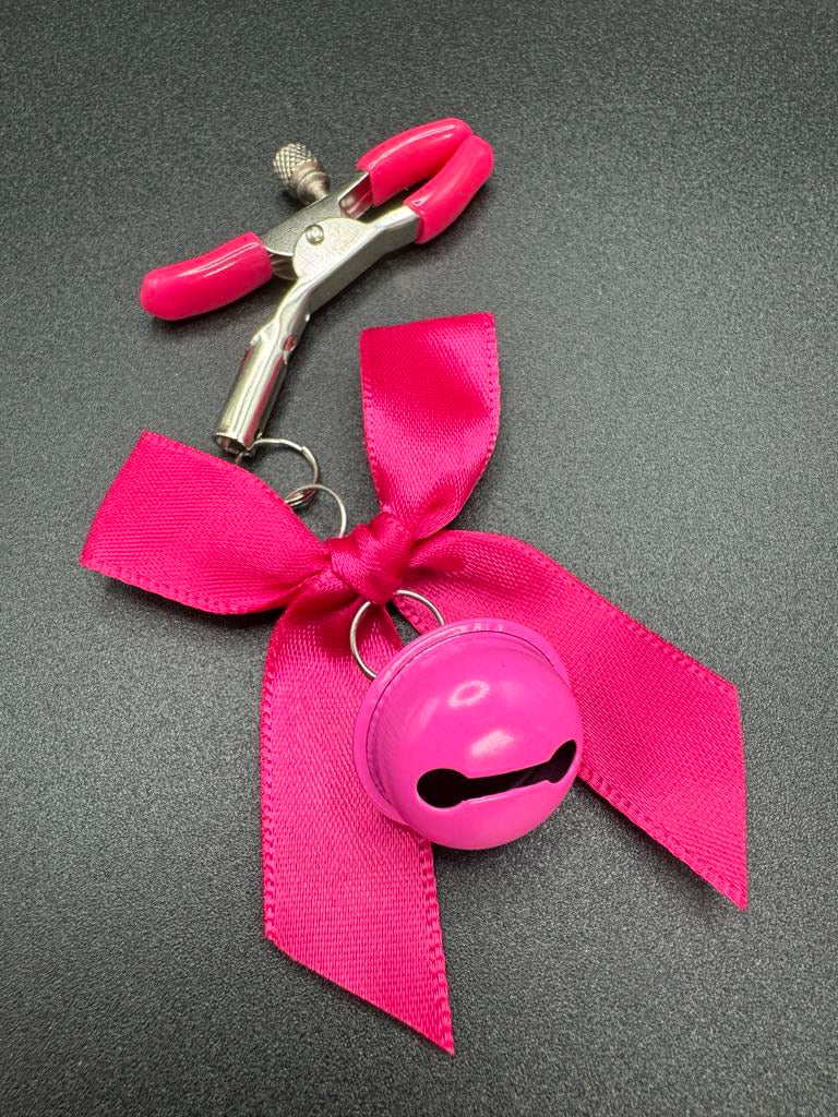 Stainless steel nipple clamp with attached bows and bells at the ends, featuring a silicone cover for added comfort and a stylish, playful touch.