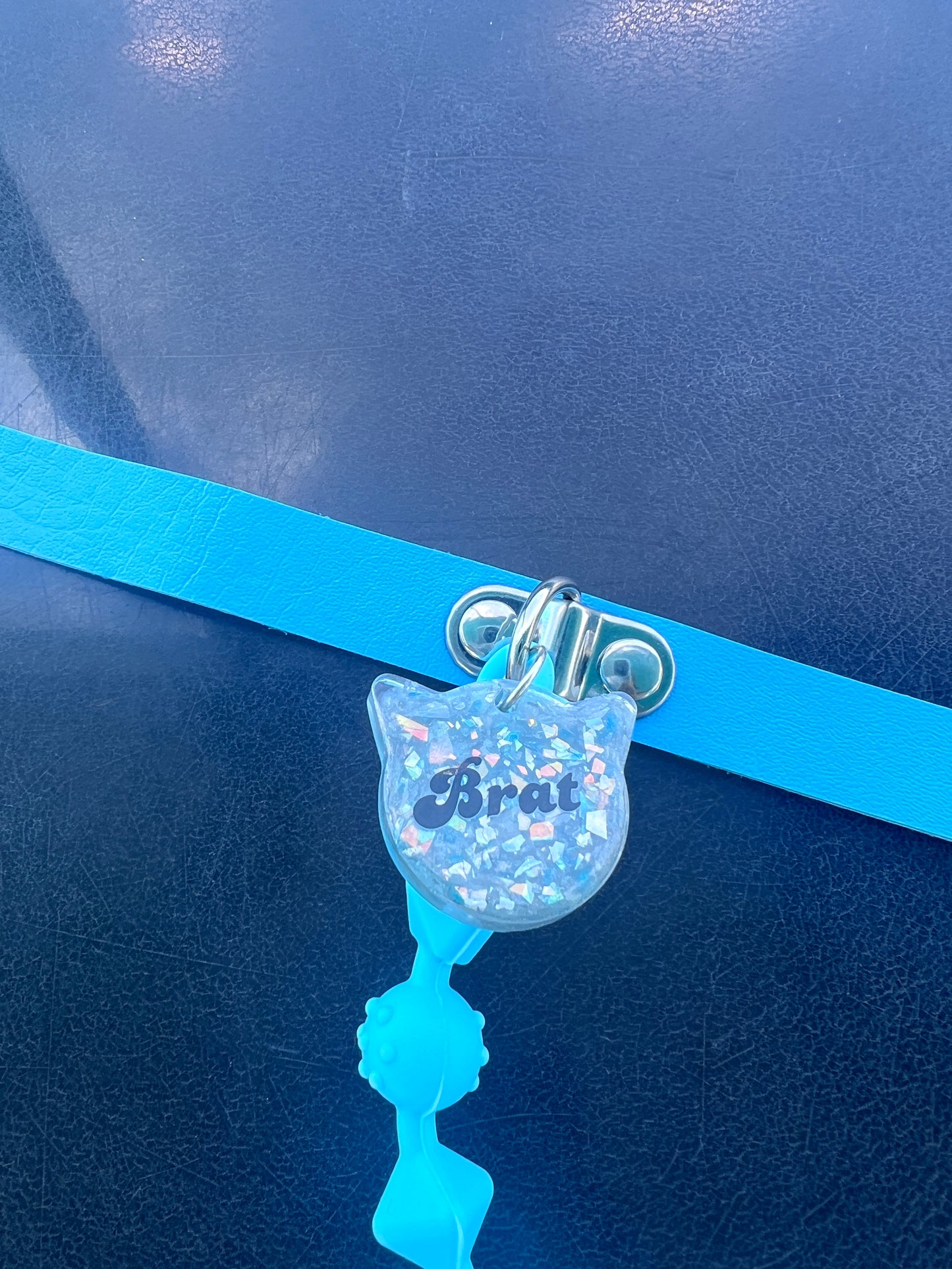 Close up view of Brat resin tag in shape of a cat head