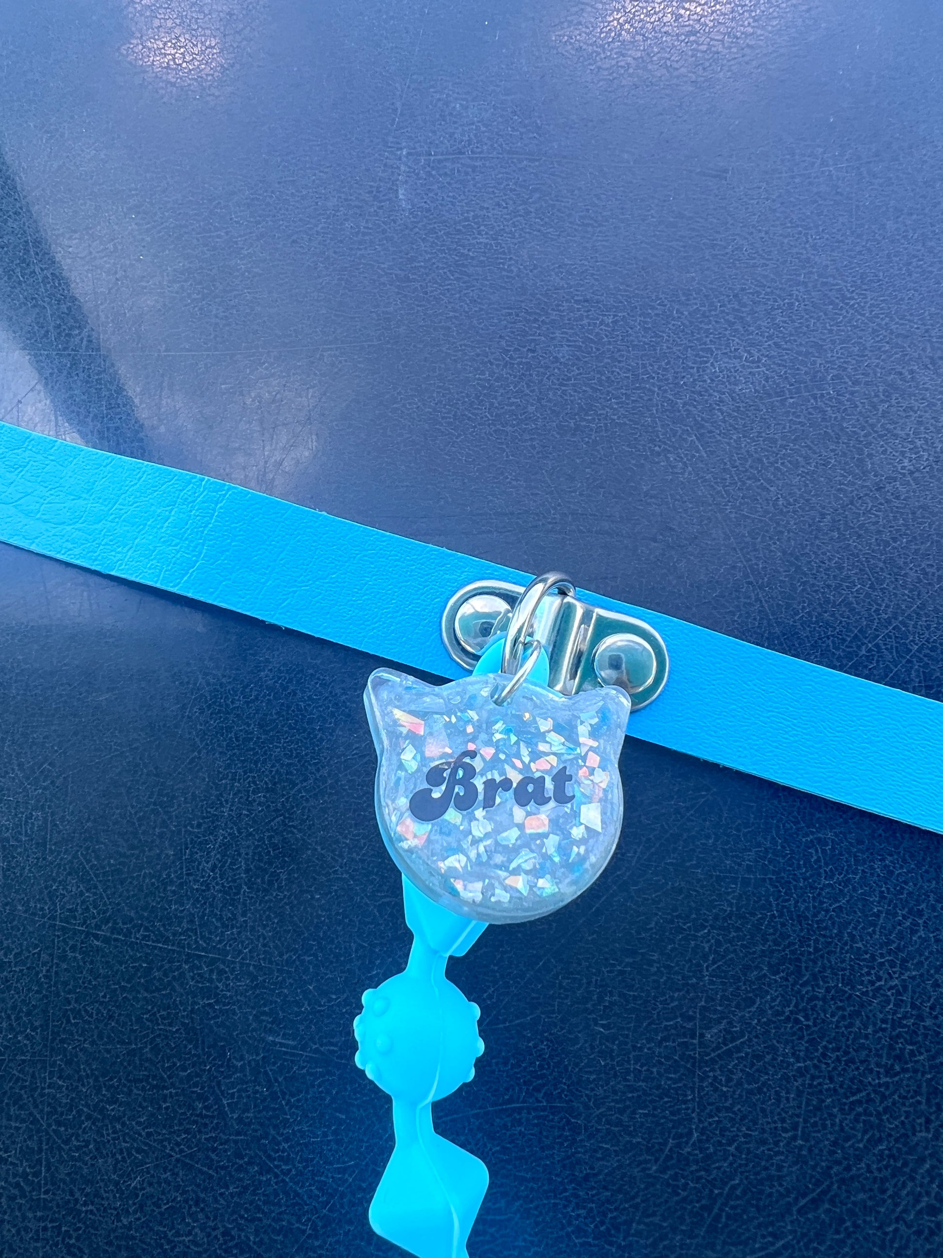 Close up view of Brat resin tag in shape of a cat head