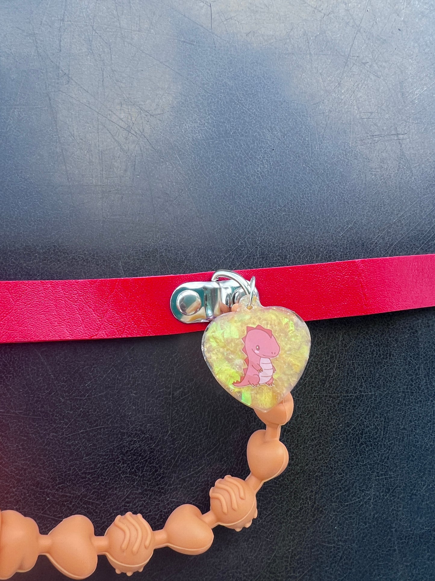 clode up of gold glitter resin tag with a red dinosaur image