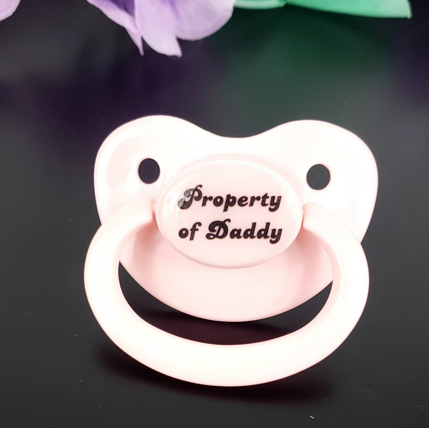 Baby Pink adult pacifier with bold text saying "Property of Daddy" in the center, adding a playful and loving sentiment.