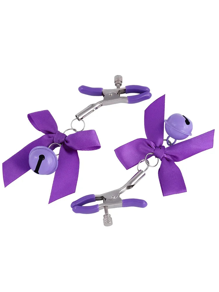 Stainless steel nipple clamps with purple attached bows and bells at the ends, featuring a silicone cover for added comfort and a stylish, playful touch.