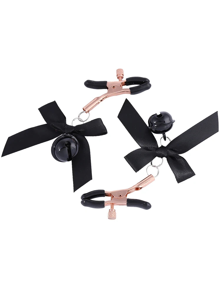 Stainless steel nipple clamps with attached bows and bells at the ends, featuring a silicone cover for added comfort and a stylish, playful touch.