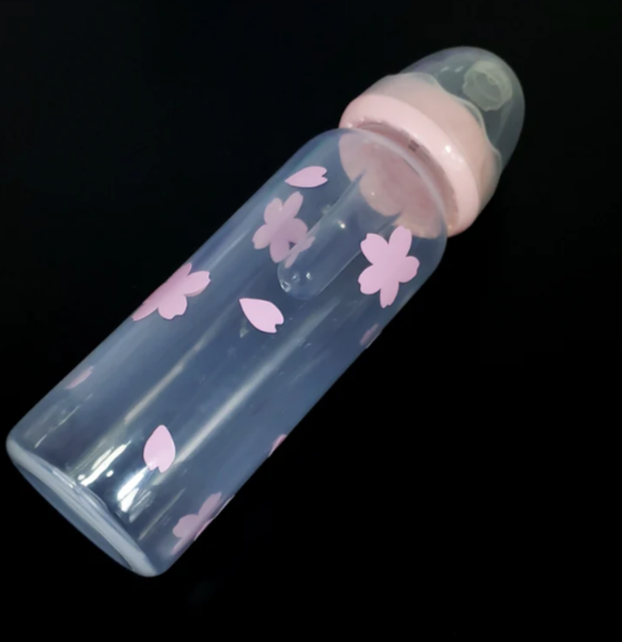 An 8oz adult baby bottle featuring a delicate sakura cherry blossom theme, with soft pink flowers and petals elegantly wrapping around the bottle for a serene and charming design.