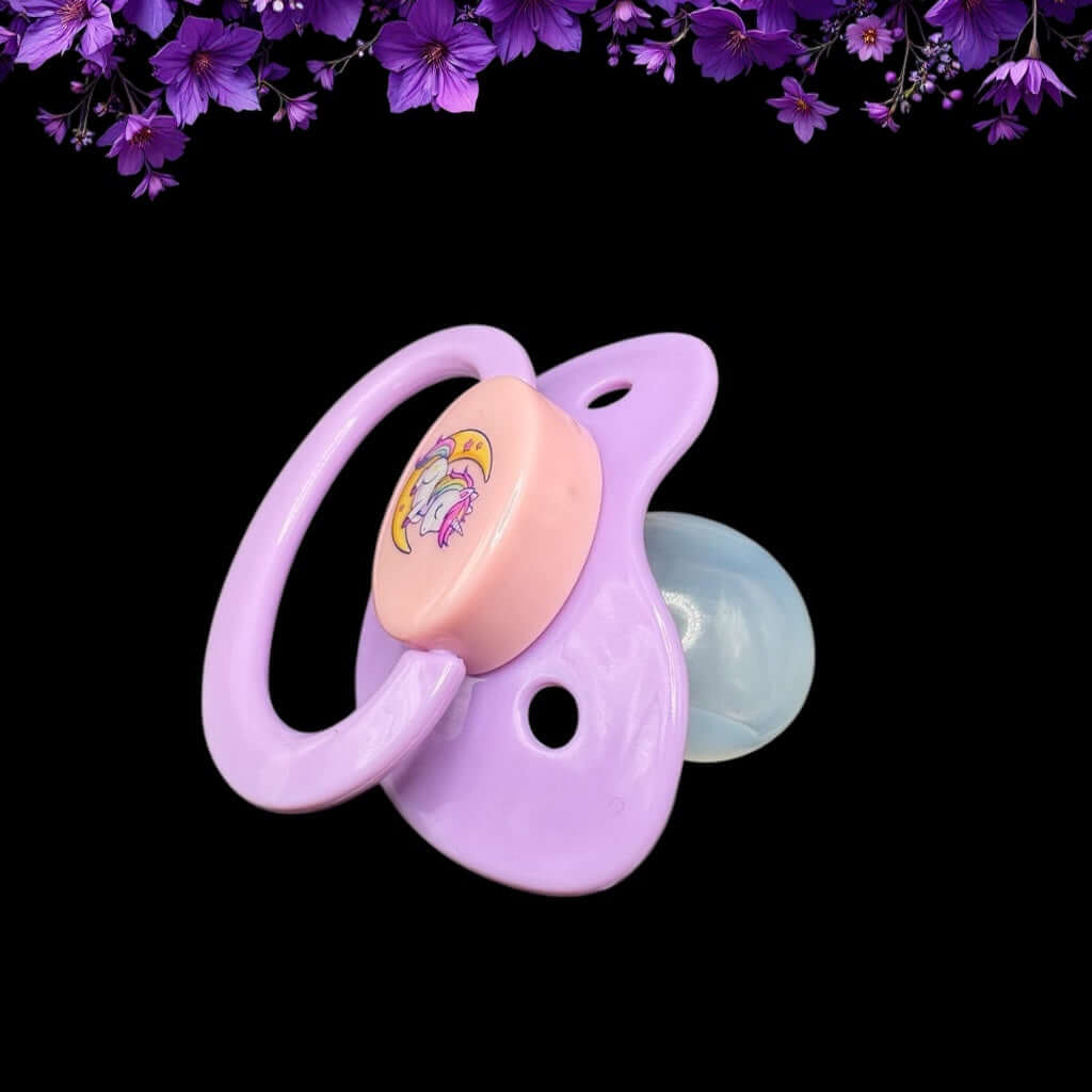 Enjoy our adorable adult pacifier featuring a Kawaii unicorn sitting on the moon in the center with the option to add your own custom text to the handle.