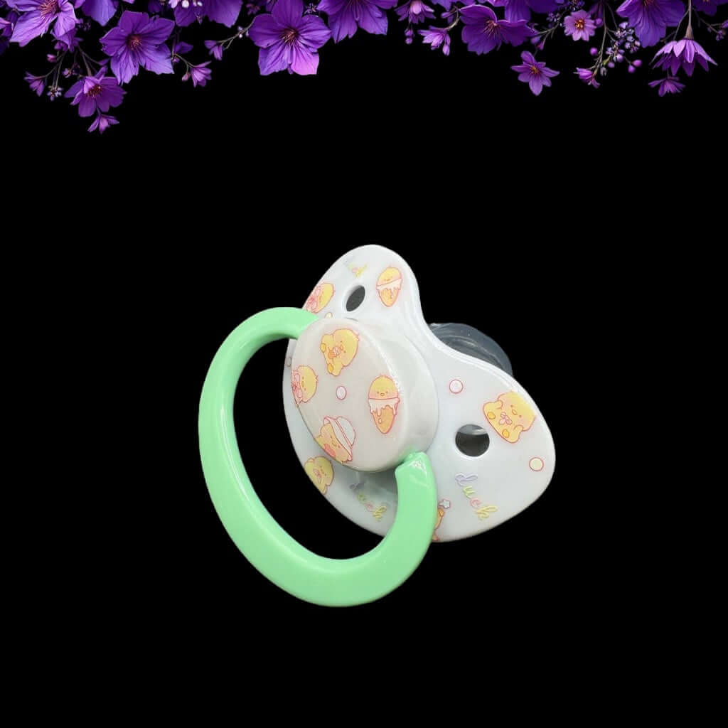 ABDL pacifier featuring a cute yellow duck design on the shield and button, adding a playful and adorable touch.