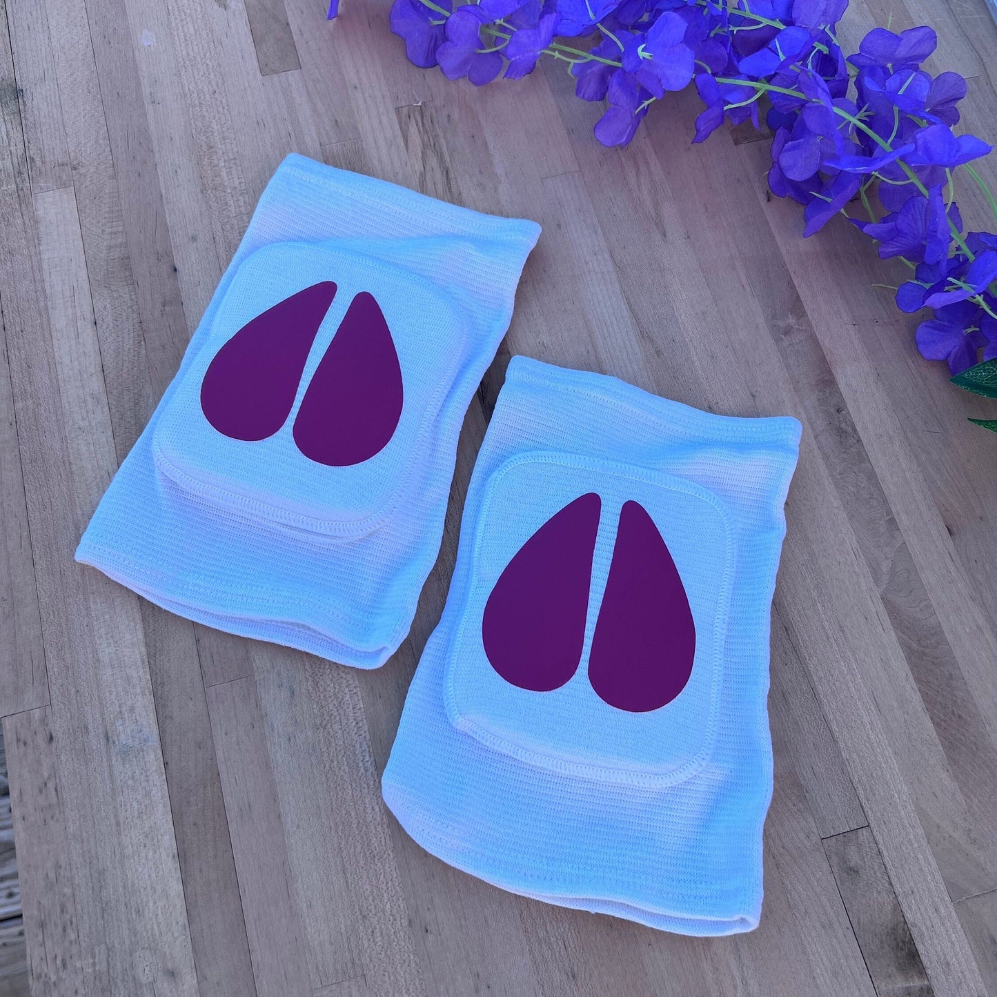 Pair of white adult knee pads with matching hot pink cow hoof centers for pet play aesthetics.