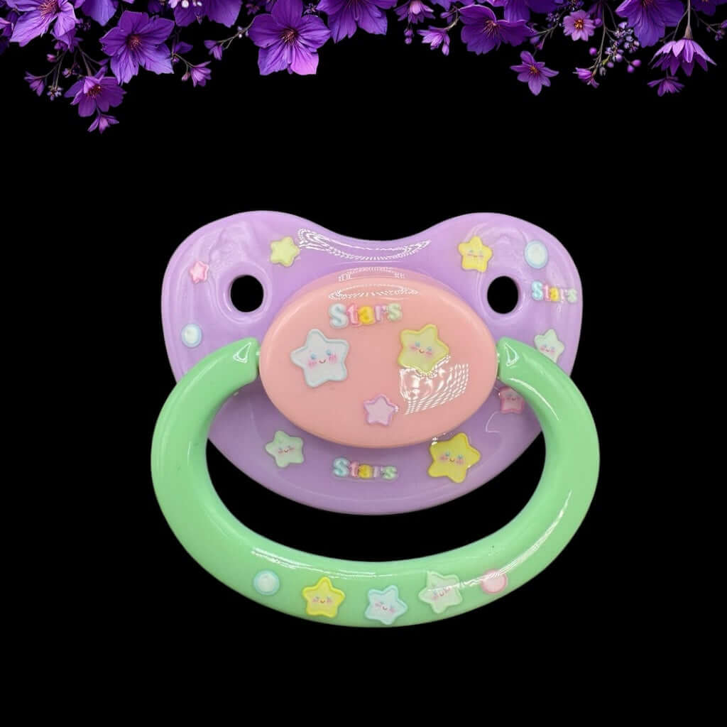 Adult pacifier in pastel pink, mint, and lavender with glow in the dark stars design