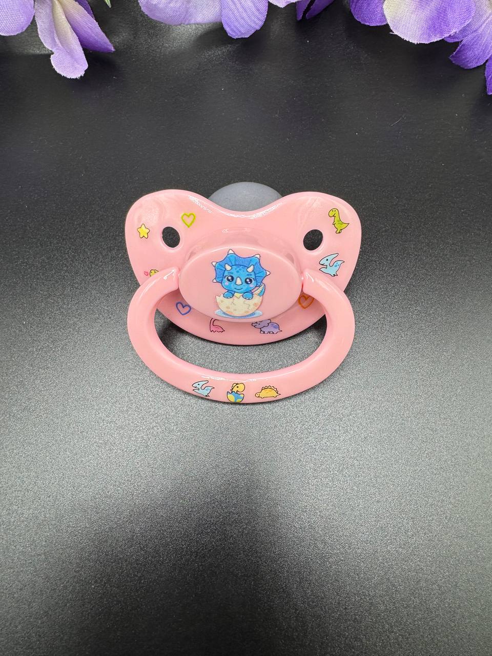 ABDL pacifier with blue baby triceratops and glow in the dark designs
