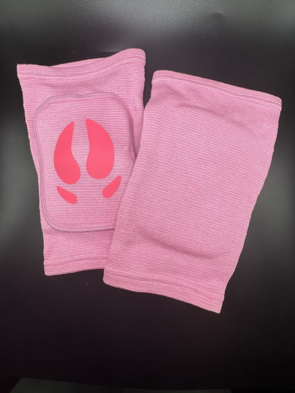 Front and back view of pink knee pads with pig hoof image on front 