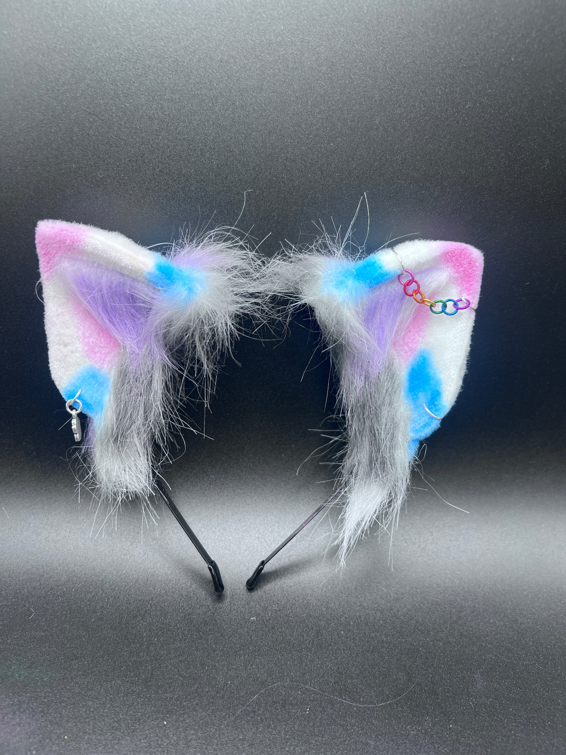 Colorful cat ears with white fur on a black background