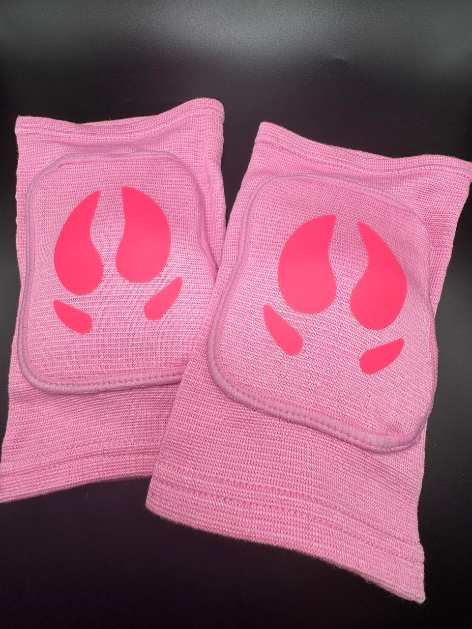 A pair of knee pads with pig hooves in the center for pig pet play
