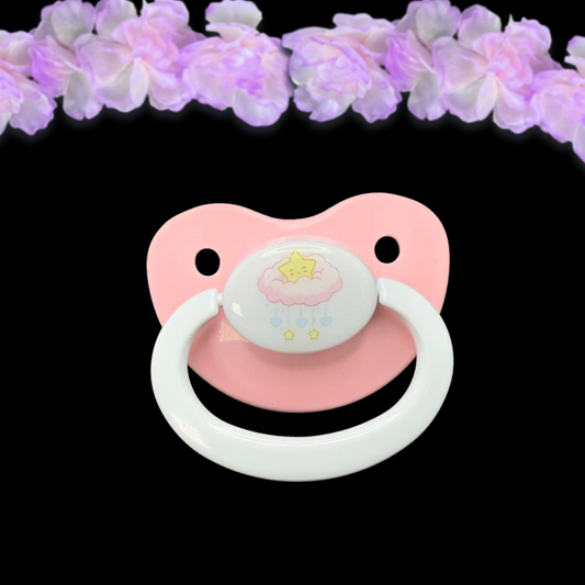 adult pacifier featuring a kawaii image in the center of a cute pink cloud baby mobile with a kawaii star on top