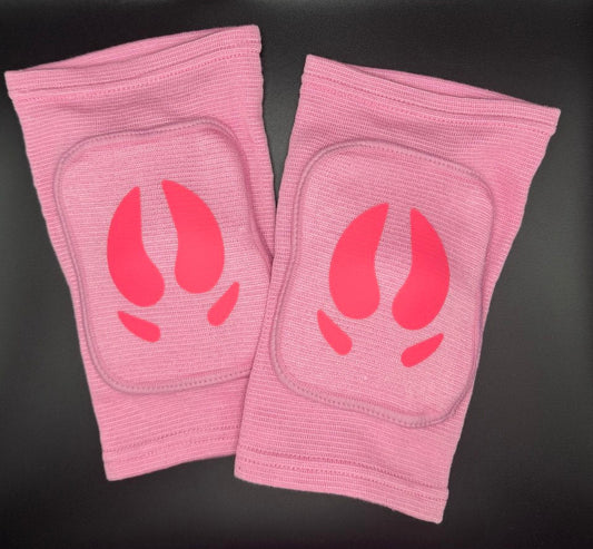 A pair of pink knee pads with hot pink pig hooves in center