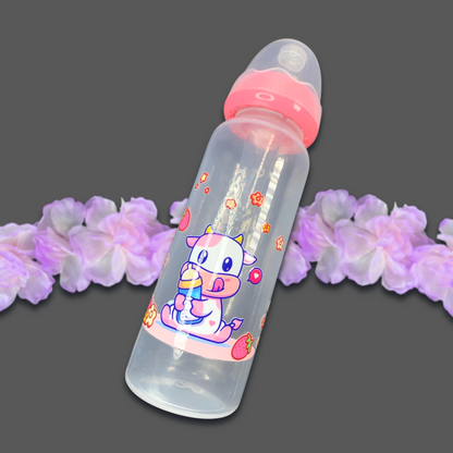 An 8oz adult baby bottle featuring a cute strawberry cow theme, with a playful pink cow, flowers, and strawberries wrapped around the bottle, creating an adorable and sweet design.