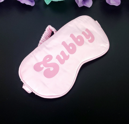 Baby pink eye mask with the text Subby in pink lettering