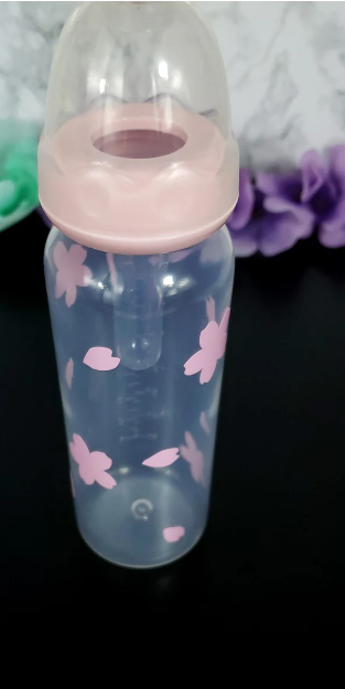 An 8oz adult baby bottle featuring a delicate sakura cherry blossom theme, with soft pink flowers and petals elegantly wrapping around the bottle for a serene and charming design.