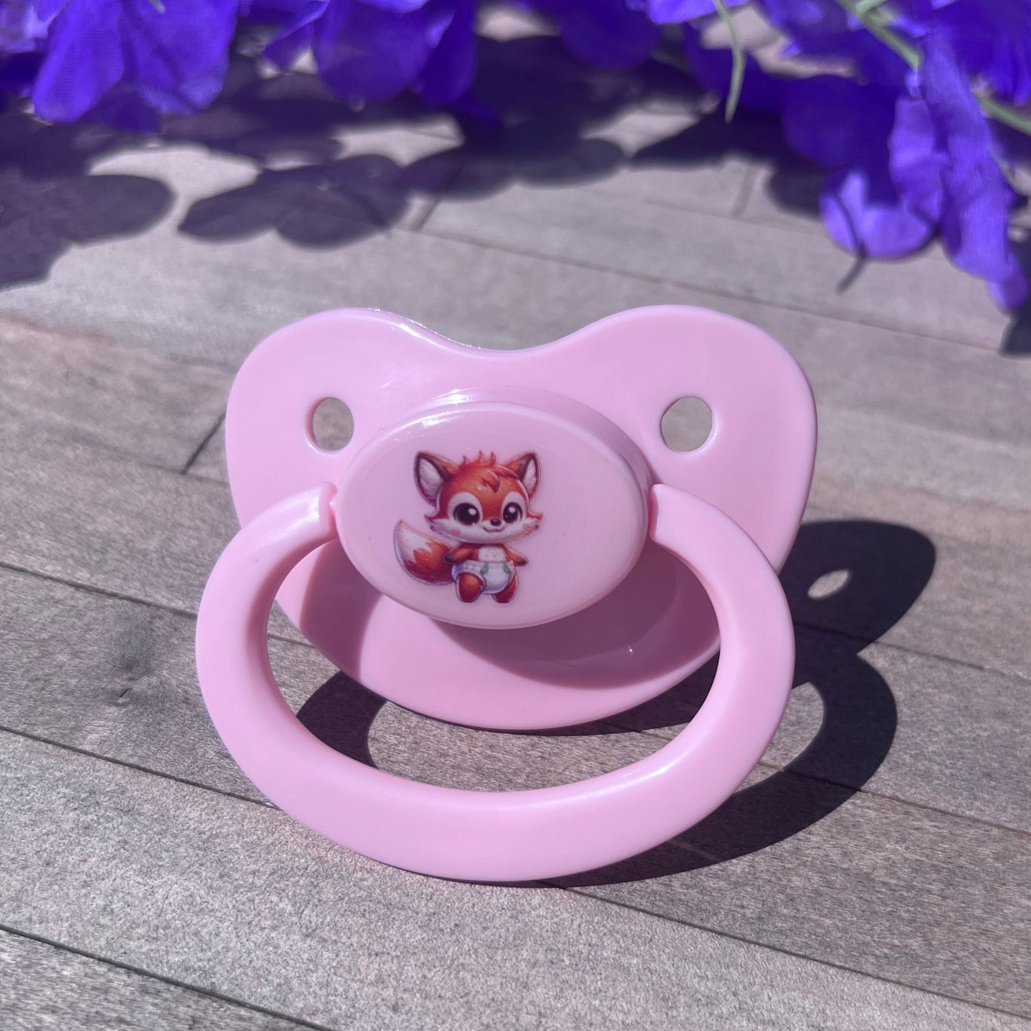 ABDL baby pink adult pacifier featuring a cute fox wearing a diaper in the center