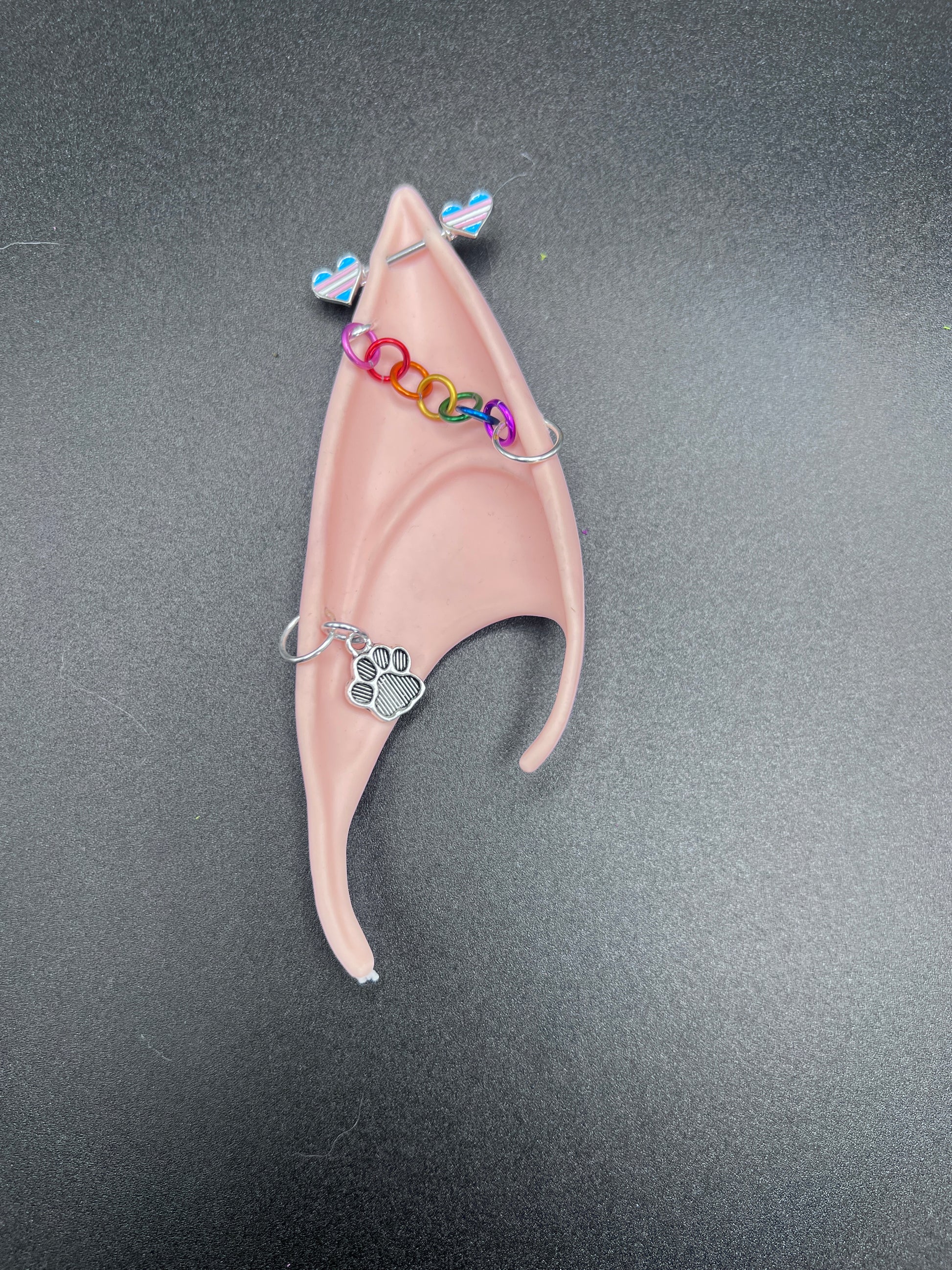Pink fairy ear with decorative elements on a gray background
