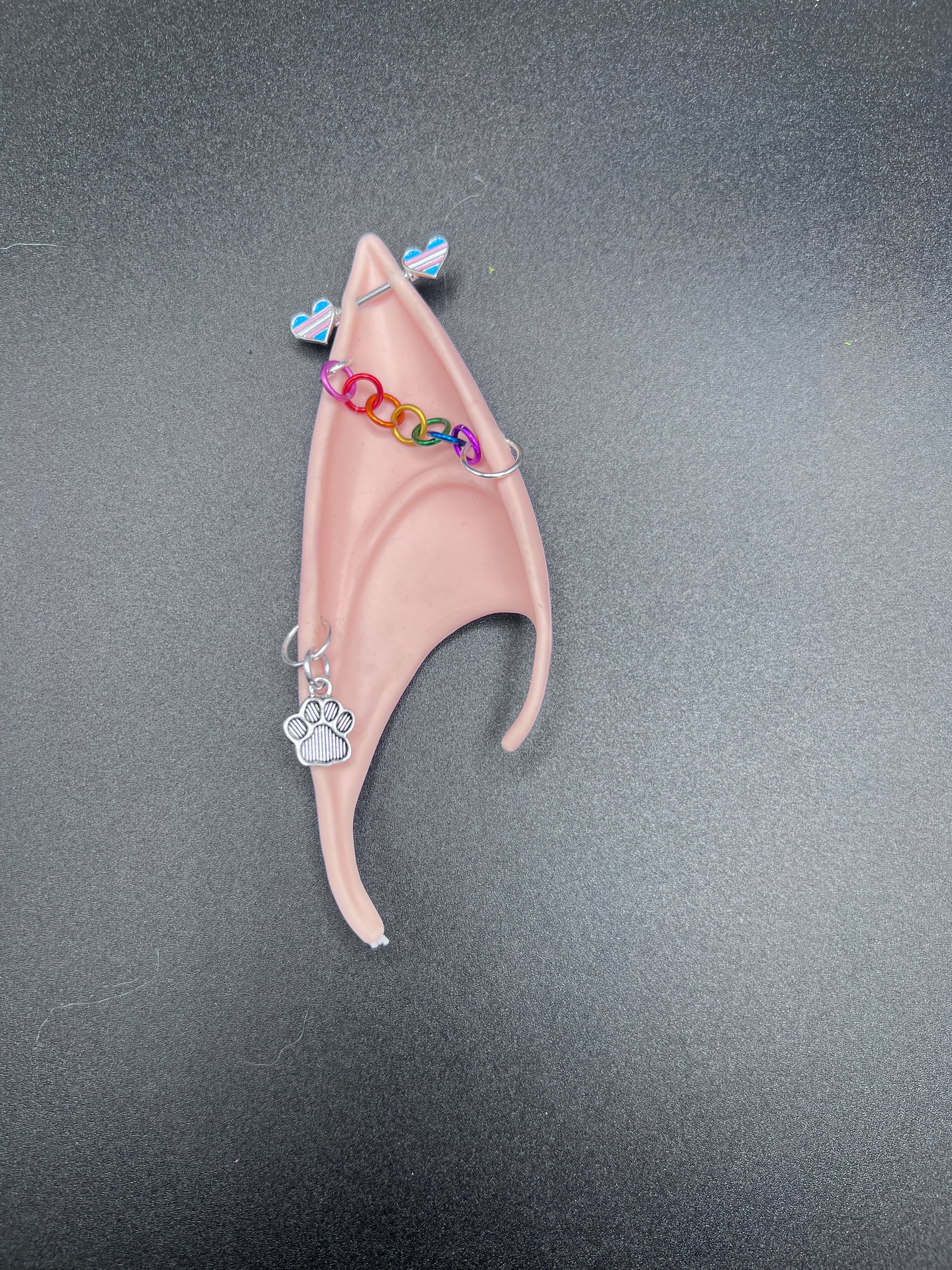 elf ear with paw charm earring, rainbow chain and barbell piercing with trans pride hearts