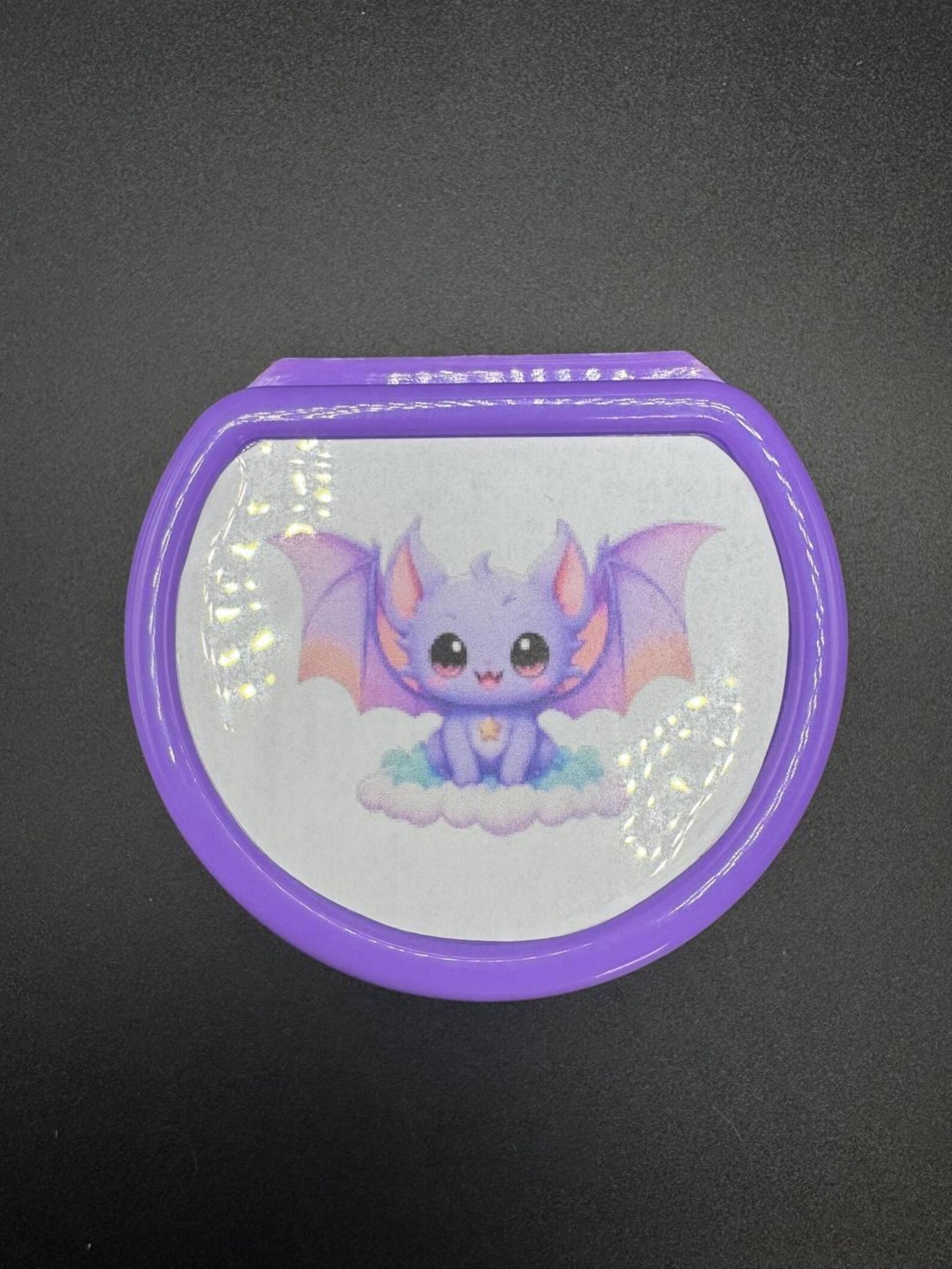 Detail of protective lid and bat artwork on adult pacifier case