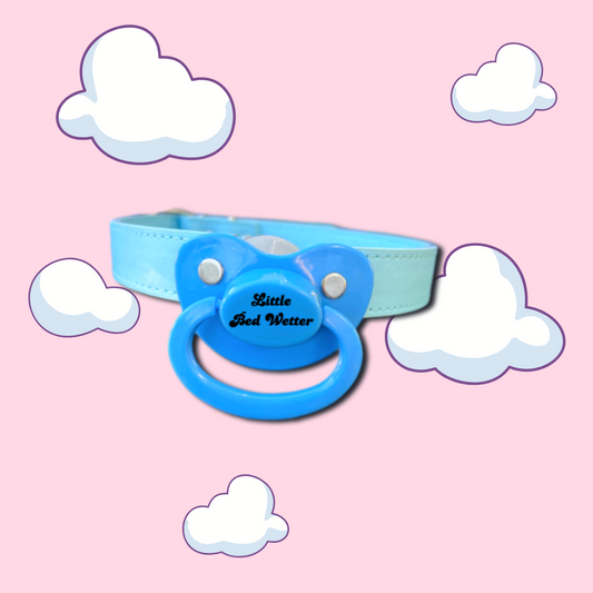 adult pacifier gag with blue stripes and text on the button that says Little Bed Wetter