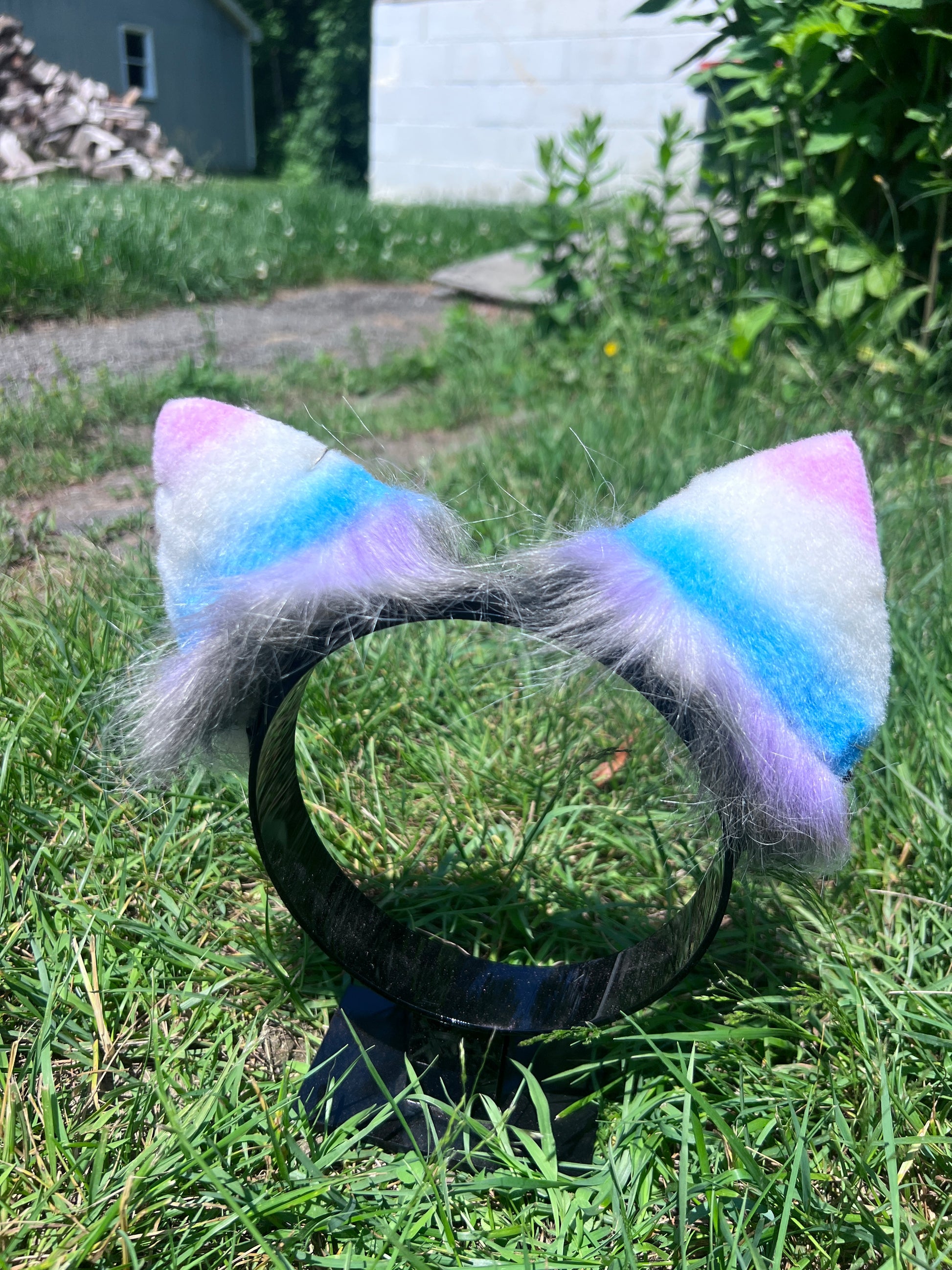 Multicolored fur cosplay kitten ears on a grassy background