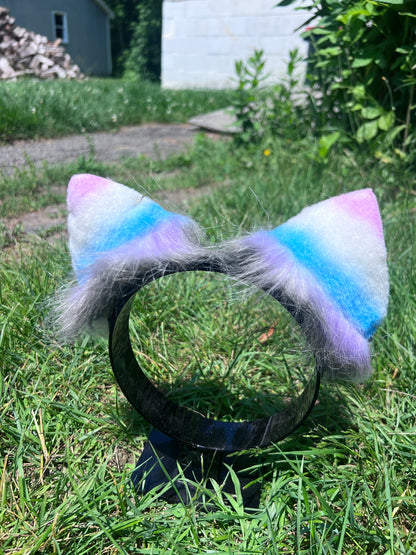 Multicolored fur cosplay kitten ears on a grassy background