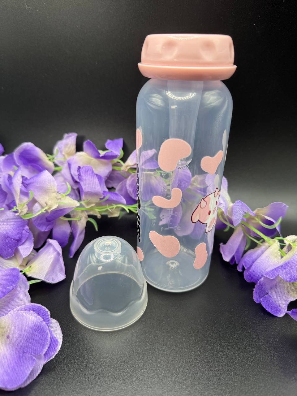 Side view of Lil Moo adult baby bottle featuring strawberry cow-inspired design